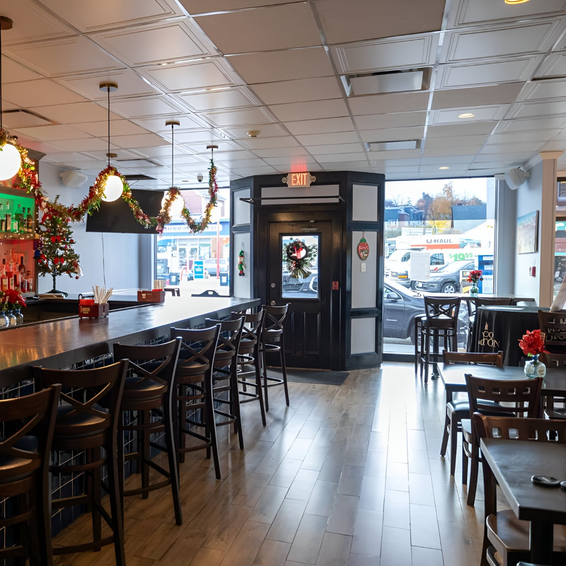 The dining room at Maura's Kitchen with its long bar, wood floors and big front windows