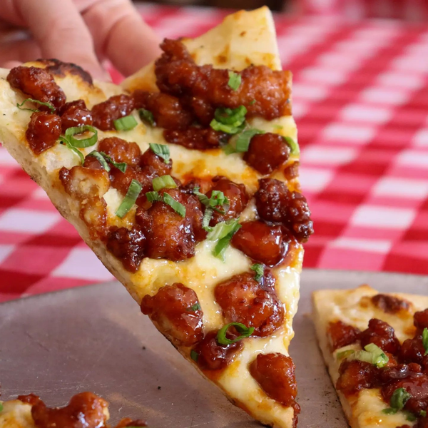 A slice of Korean white hot pizza lifted off a gingham table