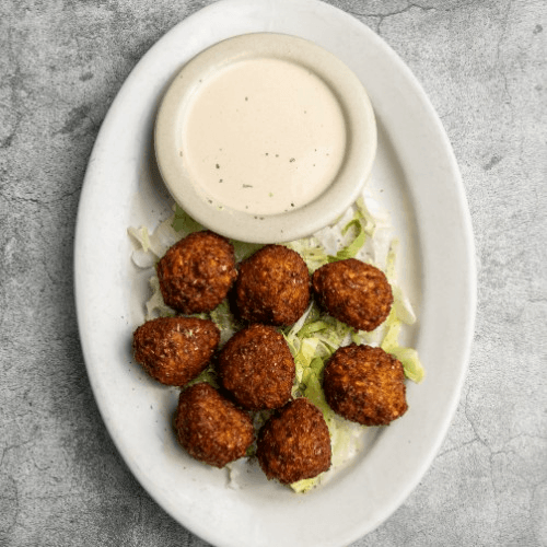 Falafel Sandwich Served with Tahini Sauce and French Fries.