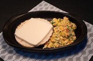 Huevos revueltos con arepa y queso / scrambled eggs with a corn cake and cheese.