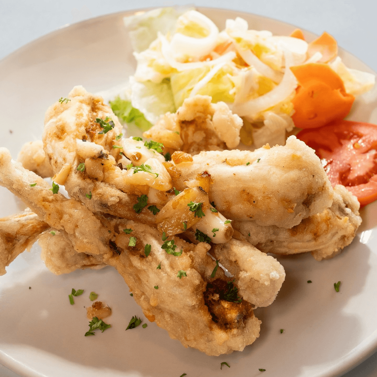 Frog legs sautéed with garlic and butter.