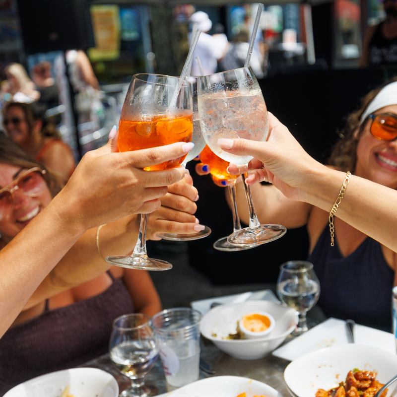 Friends toasting with orange cocktails