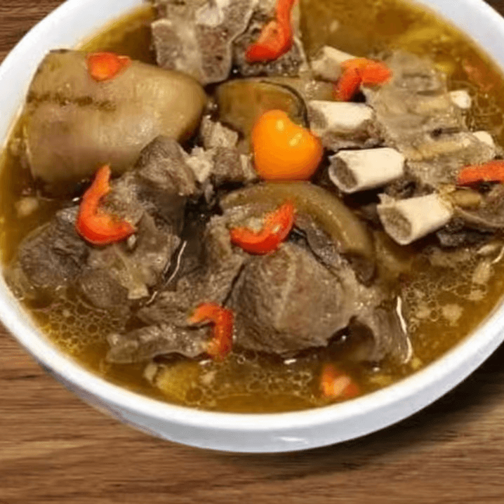 Goat Pepper Soup with White Rice, Boiled Plantains, or White Yams.