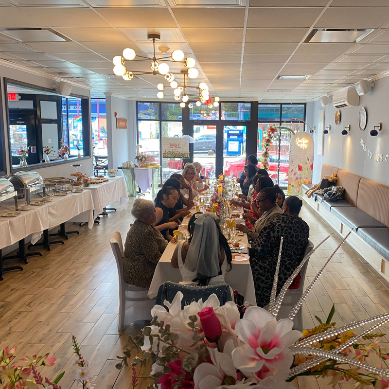 Guests at a bridal shower brunch around one long table