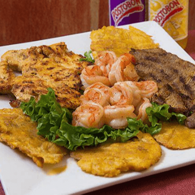 Tierra, Mar y Aire (carne, camarones y pollo) servido con ensalada y tostones